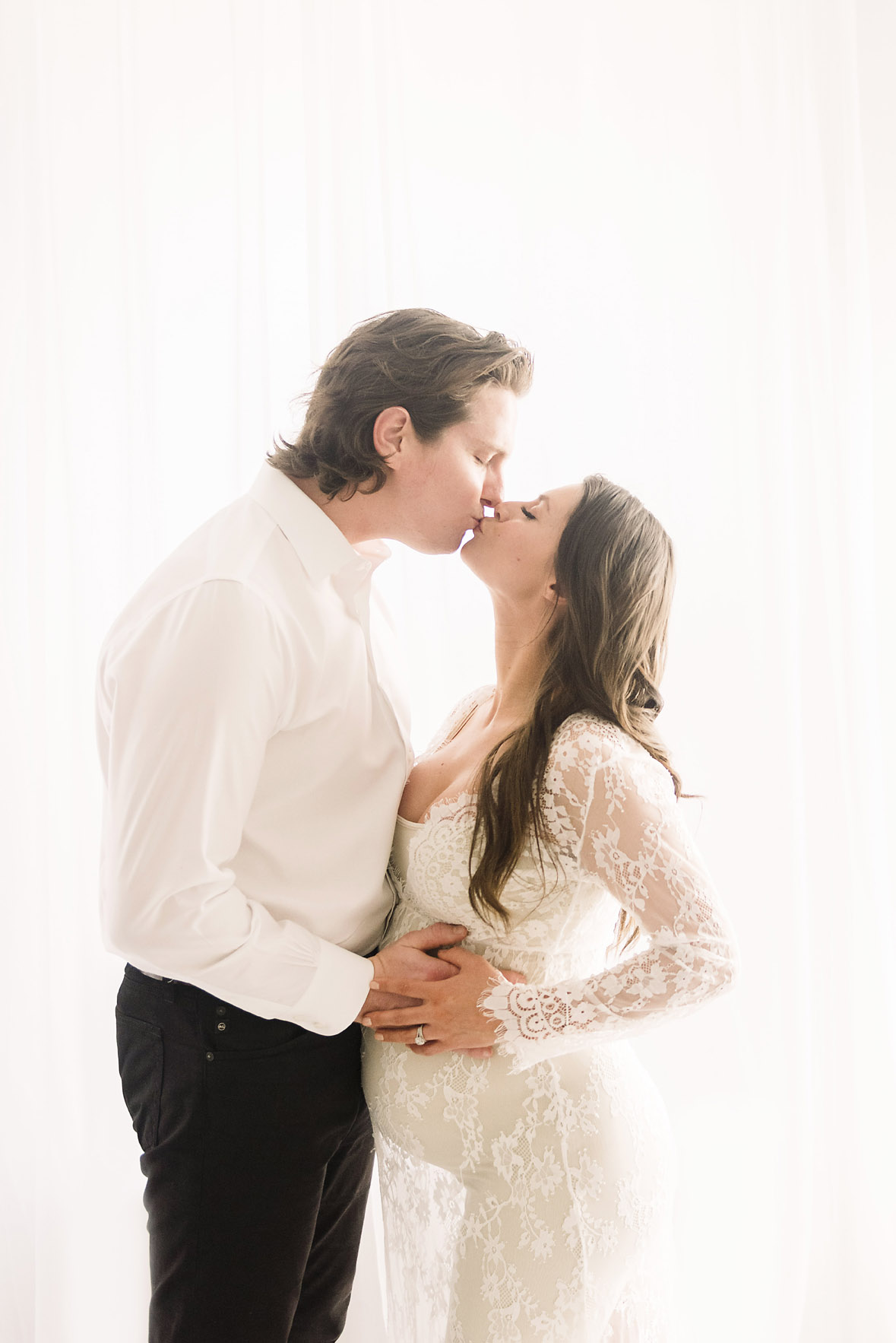 couple kissing during maternity session
