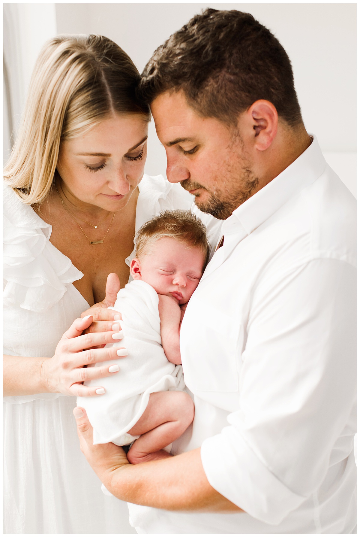 parents holding baby during in home newborn photo session
