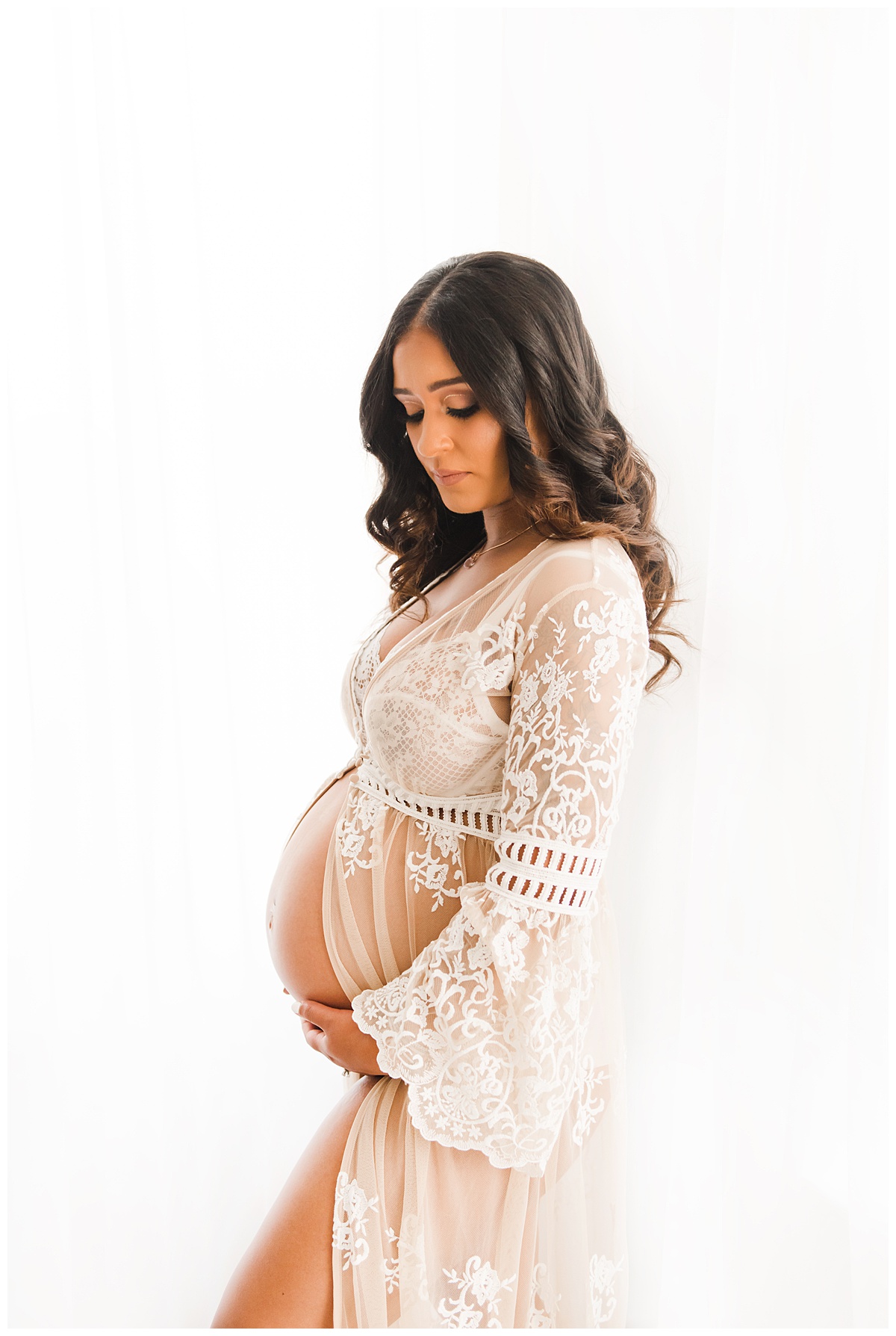 maternity photograph of a mother in a white lace dress