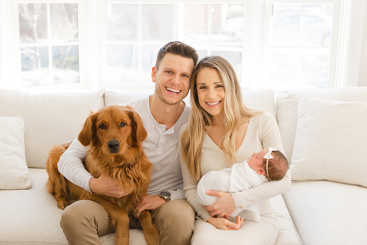 parents with newborn baby and dog